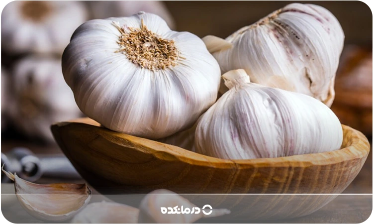 تصویر سیر درون یک ظرف چوبی را می بینید