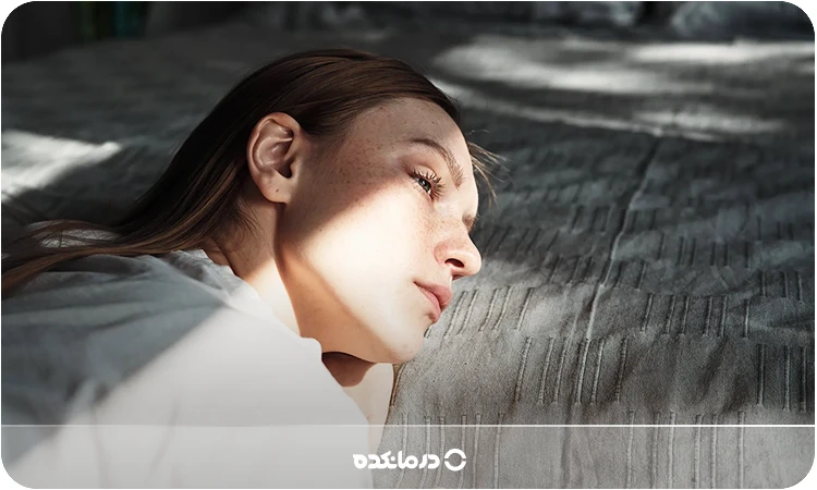 تصویر یک خانم که با ناراحتی به دوردست نگاه میکند را میبینید