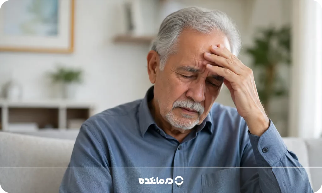 تصویر فرد مسنی که به دلیل سرگیجه دستش را روی پیشانی گذاشته