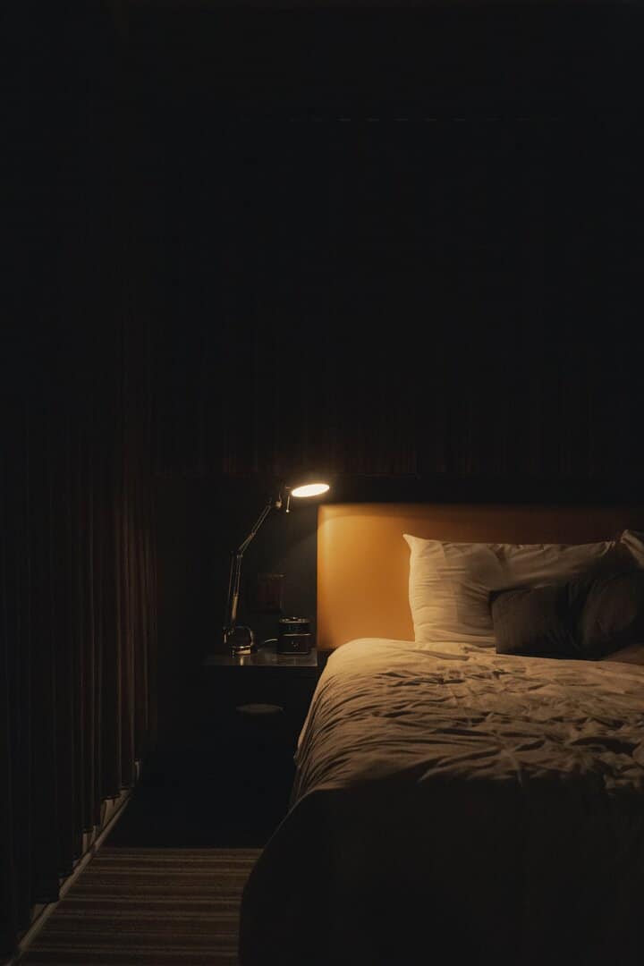 یک تخت و یک چراغ روشن در کنار آن