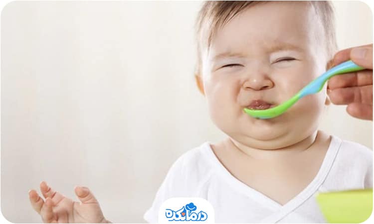 کودکی که در واکنش به قاشق غذا چشم و دهان خود را بسته است