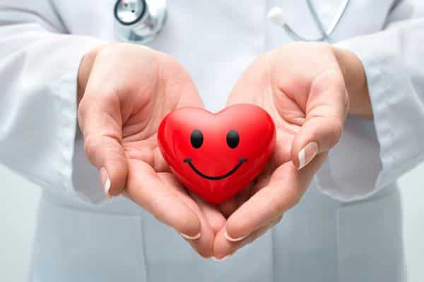 پزشکی که مولاژ قلب را با 2 دست گرفته است