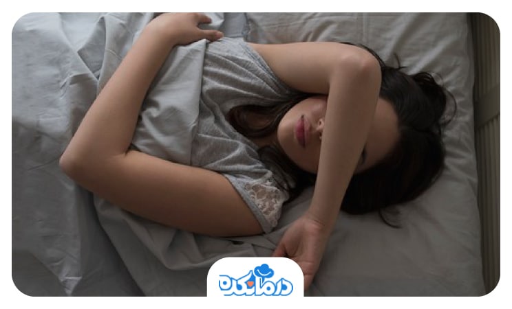 تصویر زنی که در تخت خوابیده است و دستش را روی چشمانش قرار داده