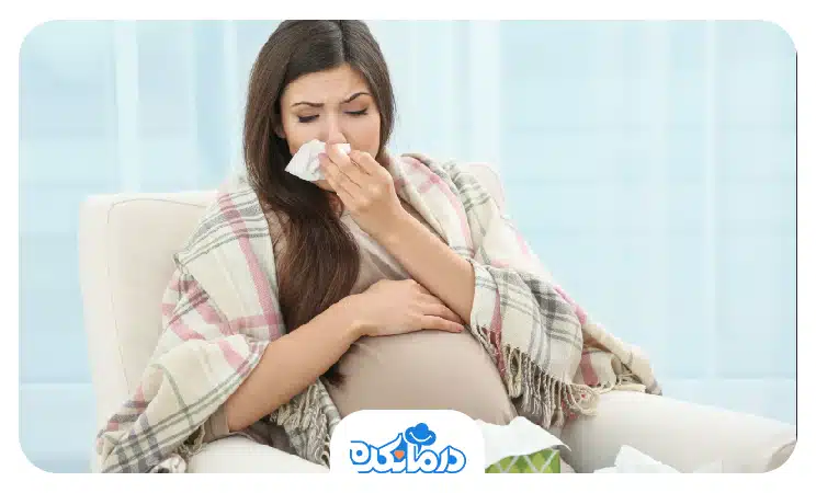  زن باردار مبتلا به آنفولانزا که بینی خود را با دستمال گرفته است
