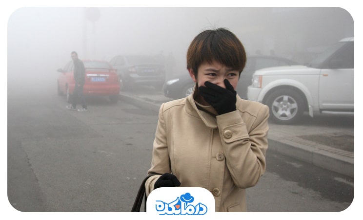 تصویر فرد مبتلا به آسم در حال سرفه در هوای آلوده