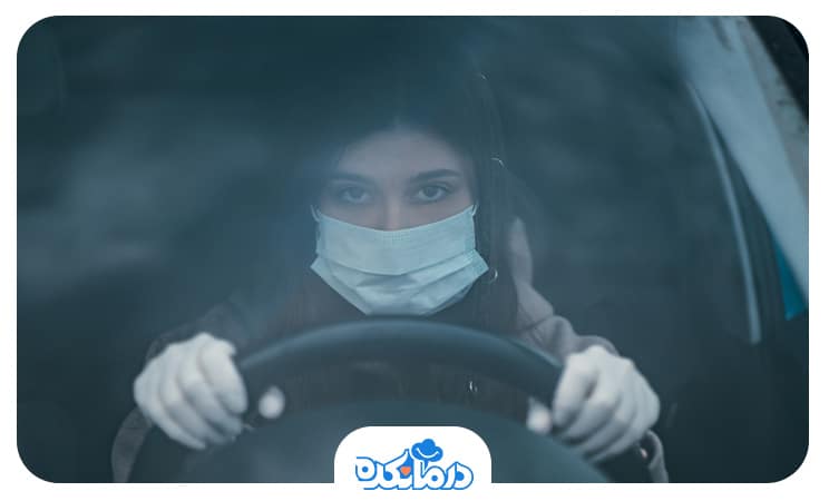 تصویر فردی که در هوای آلوده در ماشین نشسته است.
