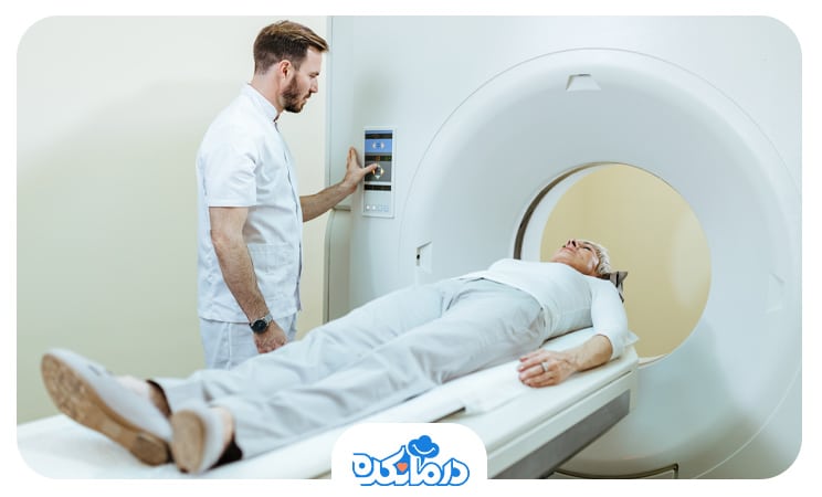 بیماری که روی تخت MRI خوابیده و پزشک در کنار تخت دستگاه را برای شروع تصویربرداری آماده می‌کند