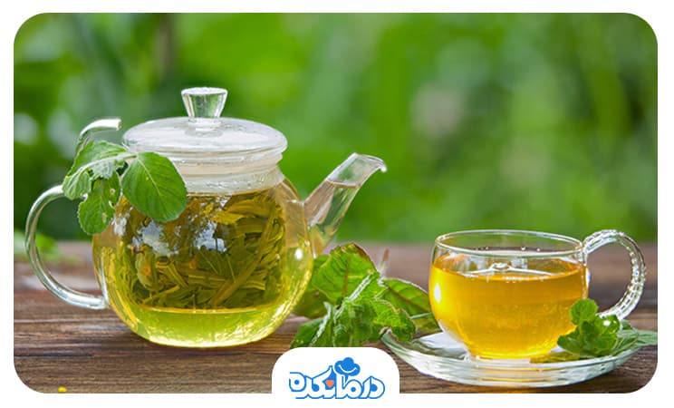 یک قوری و فنجان حاوی چای سبز