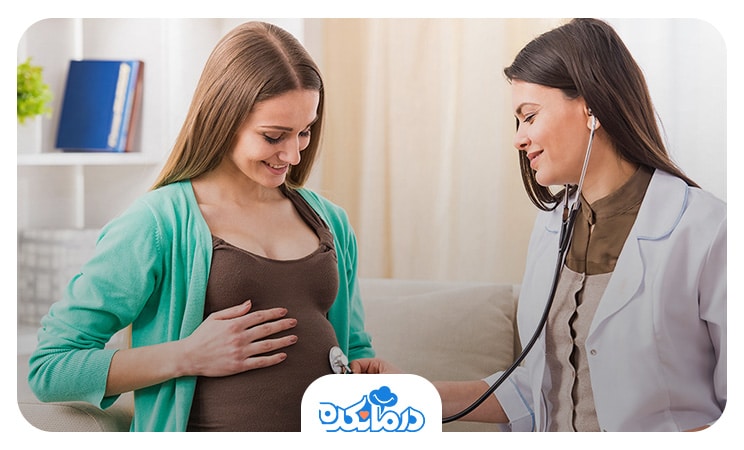 زن بادار در مطب متخصص زنان که پزشک با گوشی در حال بررسی صدای قلب جنین او است