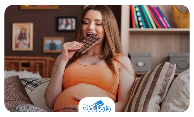 تصویر زن حامله در حال خوردن شکلات با ولع به دلیل ویار در بارداری