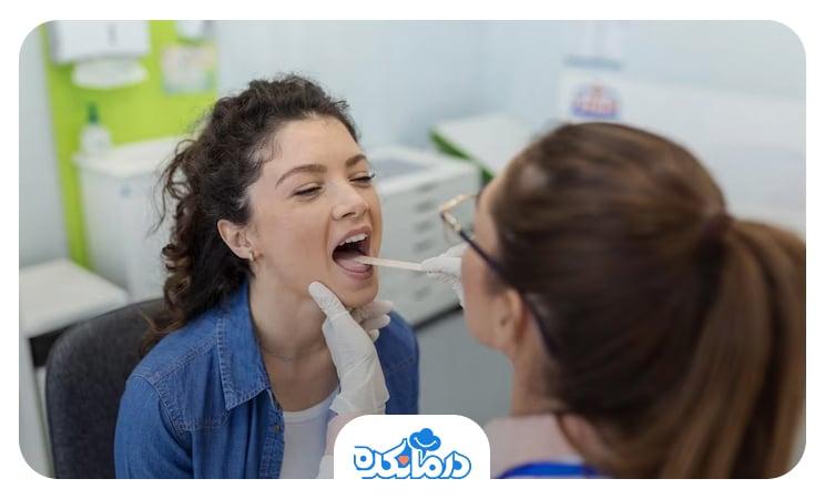 تصویر خانمی که در حال معاینه نزد دکتر است و دهانش را باز کرده و پزشک داخل دهان وی را میبیند