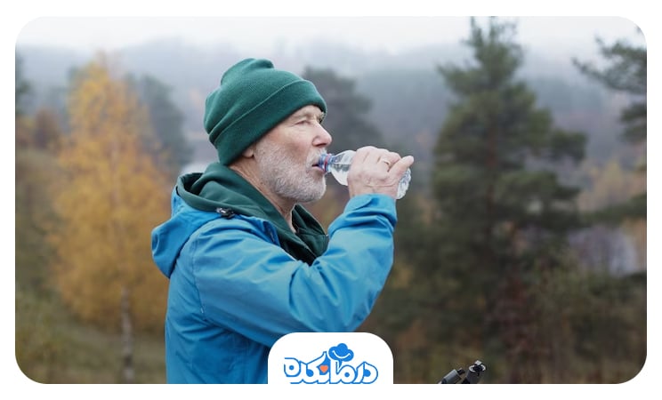 مردی که در کوهستان در حال نوشیدن آب است