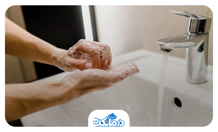 تصویر فردی که در حال شستن دست‌ها است.