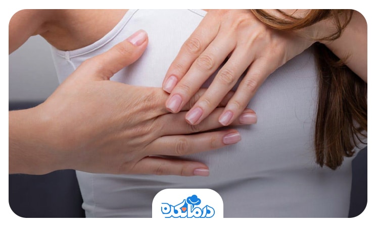 زنی که علائم بارداری را تجربه می‌کند و 2 دست خود را روی یکی از سینه‌هایش قرار داده است