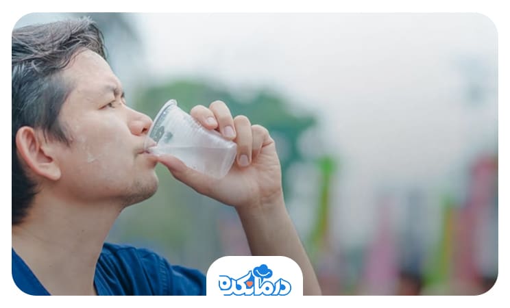 مردی که برای جلوگیری از کم‌آبی از یک لیوان یک‌بار مصرف آب می‌نوشد