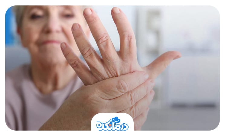 زن سالمندی که با یک دست کف دست دیگر خود را گرفته است