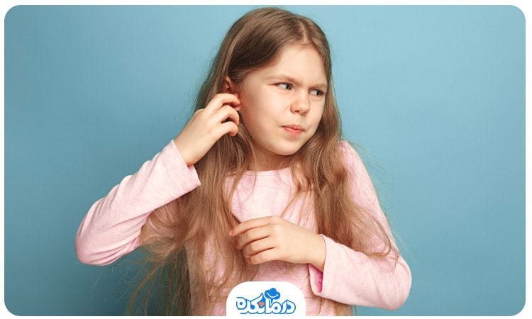 دختر بچه‌ مبتلا به بیماری کودکان که گوش خود را گرفته است
