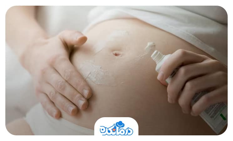 تصویر خانم بارداری که ضد آفتاب استفاده می‌کند.