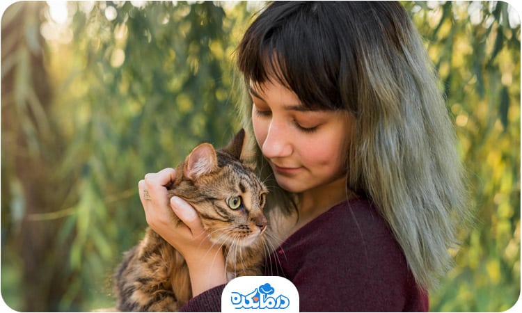 زنی که یک گربه را در آغوش گرفته است