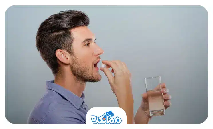 یک مرد در حال خوردن دارو است و یک لیوان آب در دست دارد