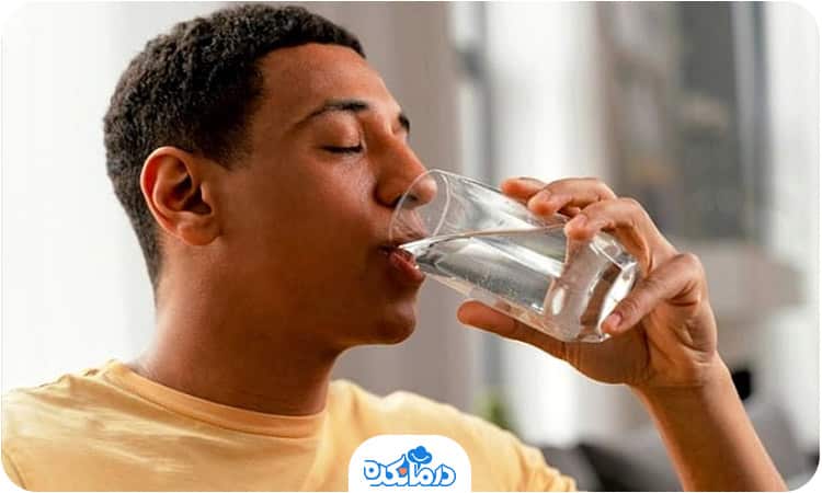 یک مرد در حال نوشیدن یک لیوان آب است