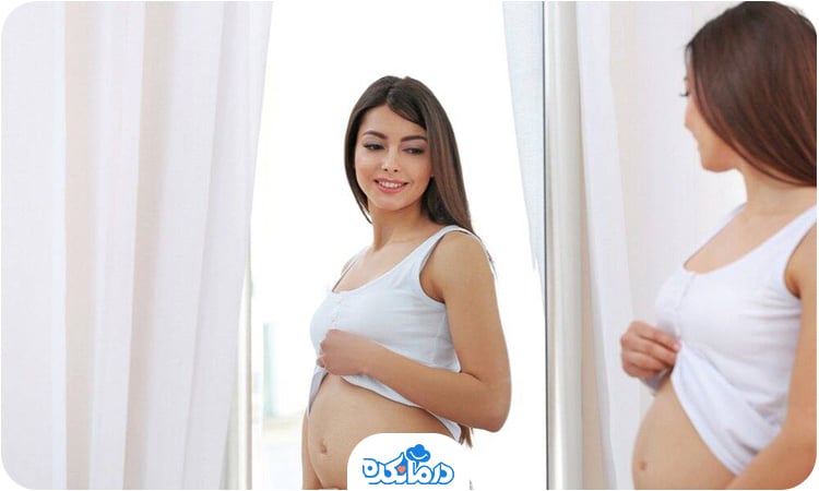 تصویر یک زن باردار که در آینه به خود نگاه می‌کند و در هفته ۲۵ بارداری است