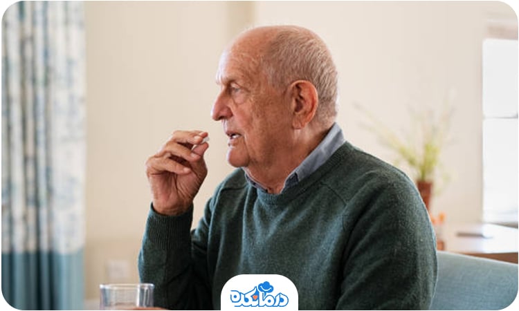 یک مرد سالمند در حال خوردن قرص است