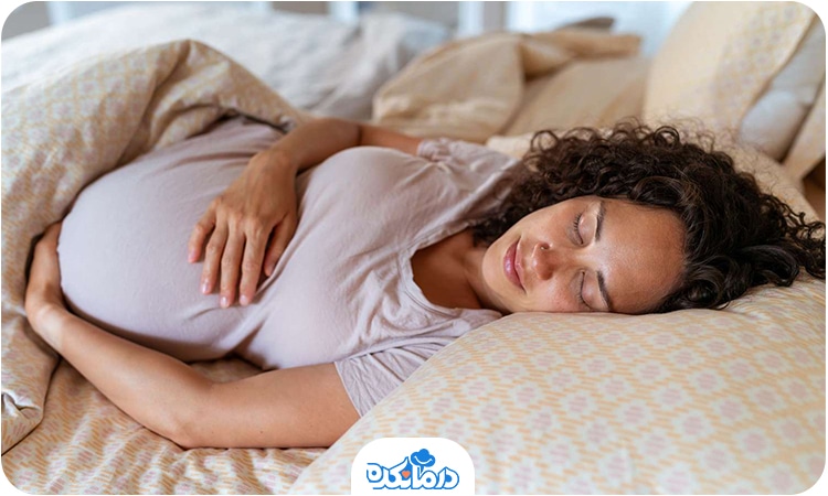 یک زن باردار که روی تخت خوابیده است