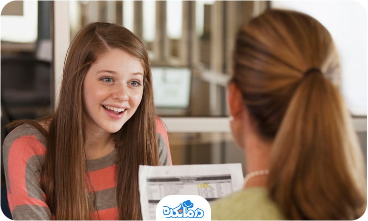 تصویری از یک نوجوان دختر در حال خندیدن با یک مشاور.