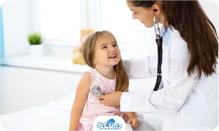پزشک یک دختربچه را معاینه و صدای قلب او را با گوشی بررسی می‌کند
