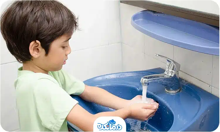 یک پسربچه دست‌های خود را می‌شوید