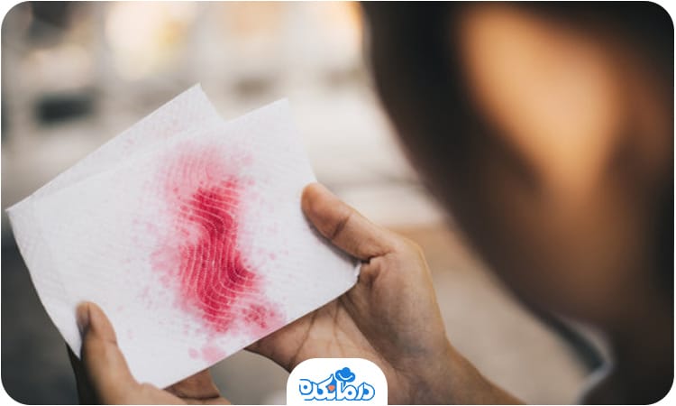 تصویر فردی در حال مشاهده دستمال خونی پس از سرفه