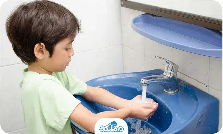 یک پسربچه که دست‌های خود را می‌شوید