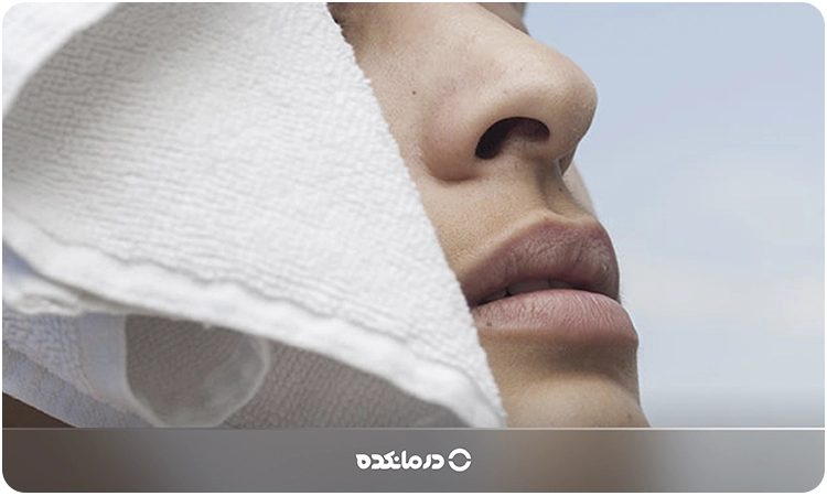 تصویر فردی که یک حوله را روی گوش خود قرار داده است