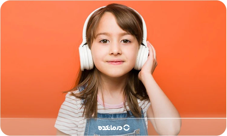 تصویر کودکی با هدفون روی گوشهایش