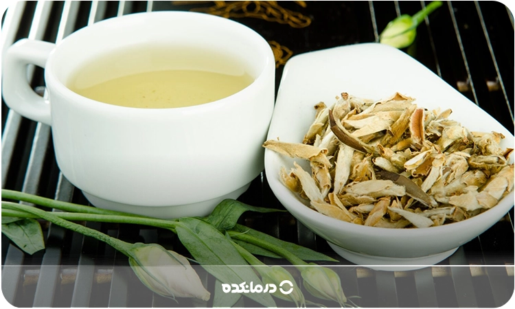 چای سفید در فنجان با برگهایش در کنار آن
