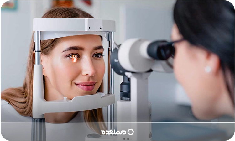 تصویر چشمپزشک در حال معاینه چشم بیمار با دستگاه مخصوص را میبینید