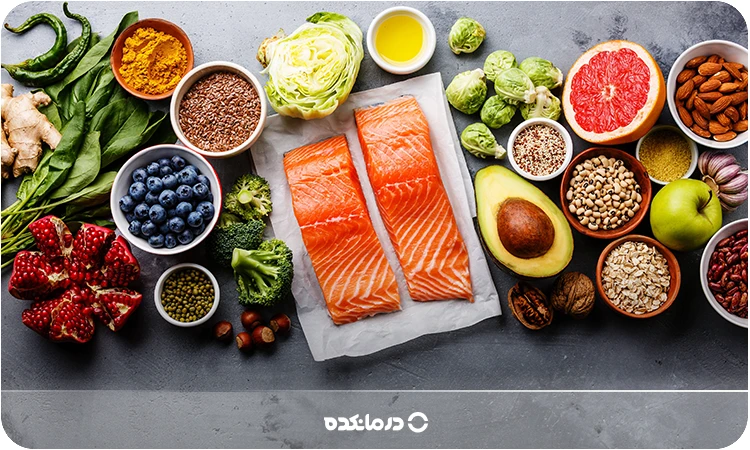 تصویر غذاهای سالم شامل انواع توت، سبزیجات برگ دار، ماهی سالمون و مرکبات را می بینید
