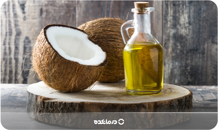 یک شیشه روغن نارگیل در کنار میوه نارگیل را می بینید