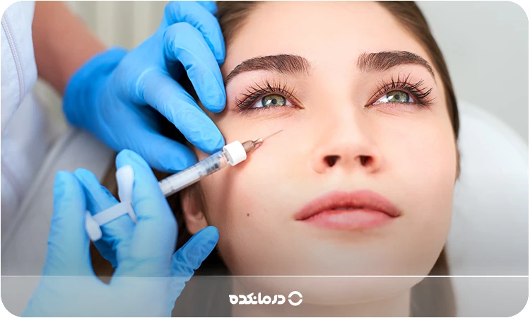 تصویر پزشک در حال تزریق فیلر به ناحیه زیر چشم را می بینید