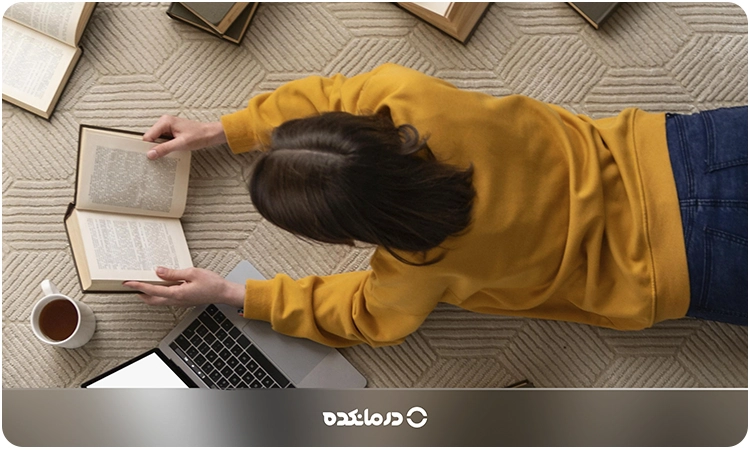 تصویر یک خانم در حال خواندن کتاب را میبینید