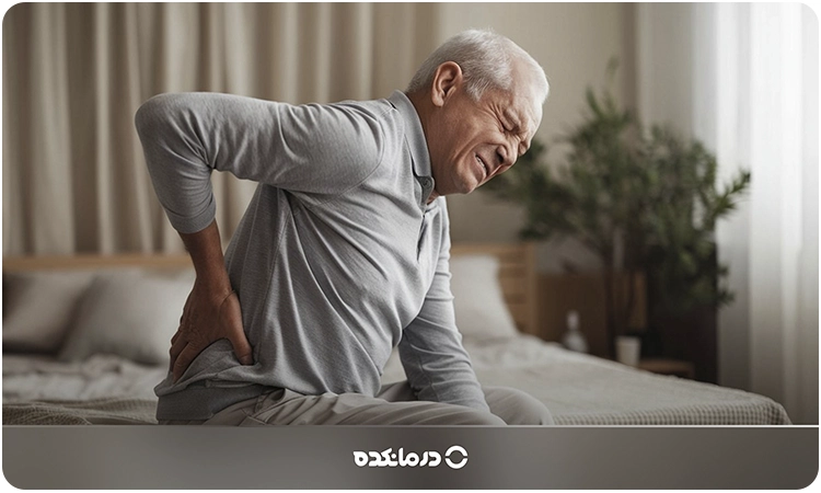 تصویر فرد مسنی که به دلیل درد دستش را روی کمرش گذاشته را می بینید