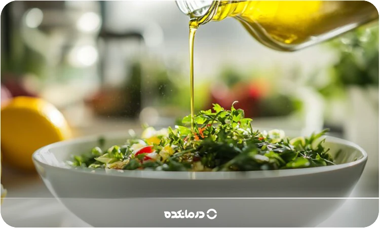 تصویر فردی که روی سالاد سبزیجات روغن زیتون میریزد را می بینید
