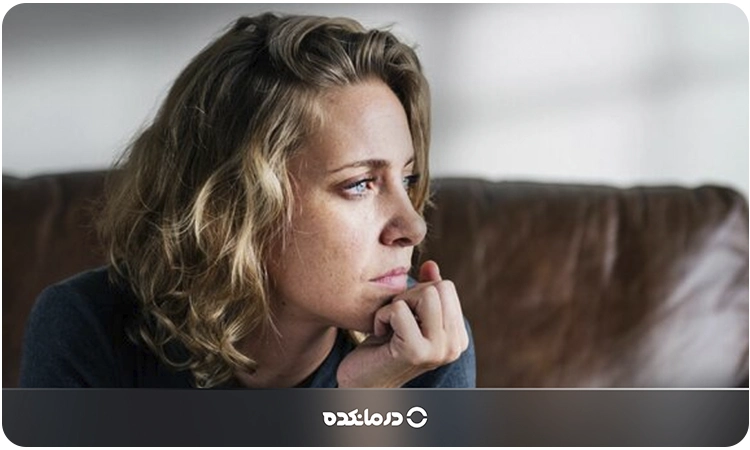 تصویر یک خانم که با ناراحتی به دوردست نگاه میکند را می بینید