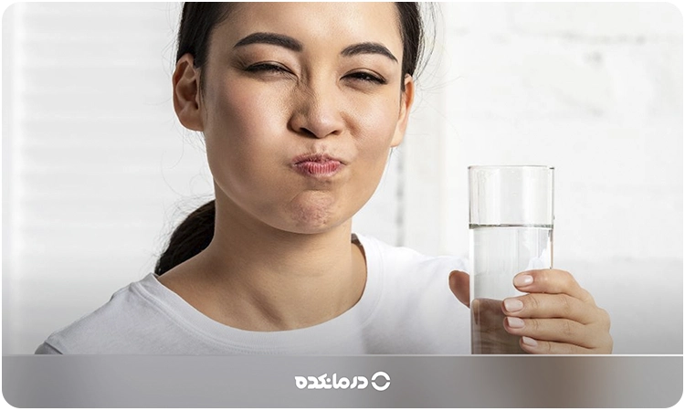 تصویر فردی که در حال استفاده از دهانشویه آب نمک است.