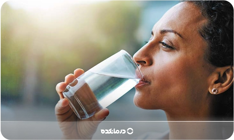 تصویر فردی در حال نوشیدن یک لیوان آب را می‌بینید