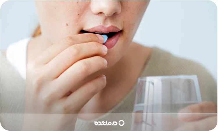 تصویر یک زن جوان که در حال خوردن قرص است را می بینید
