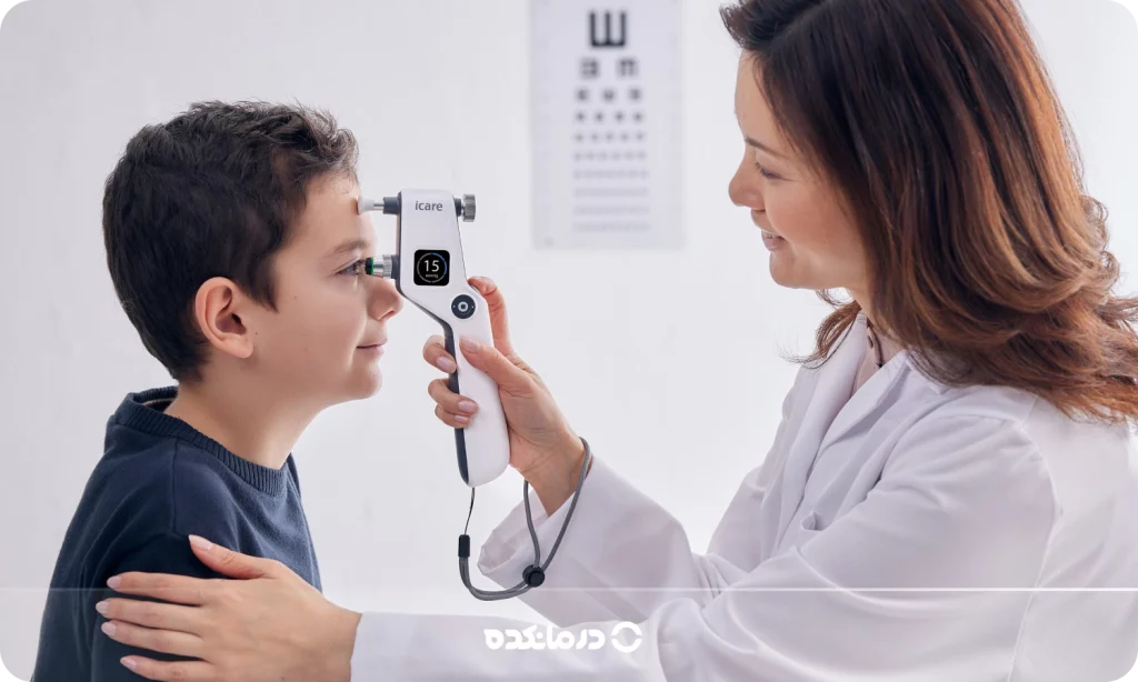 تصویر پزشک در حال معاینه چشمهای بیمار با دستگاه تونومتری را می بینید