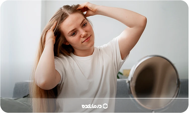 تصویر فردی که در حال نگاه کردن موهای پرپشت و سالم خود در آینه است را می بینید