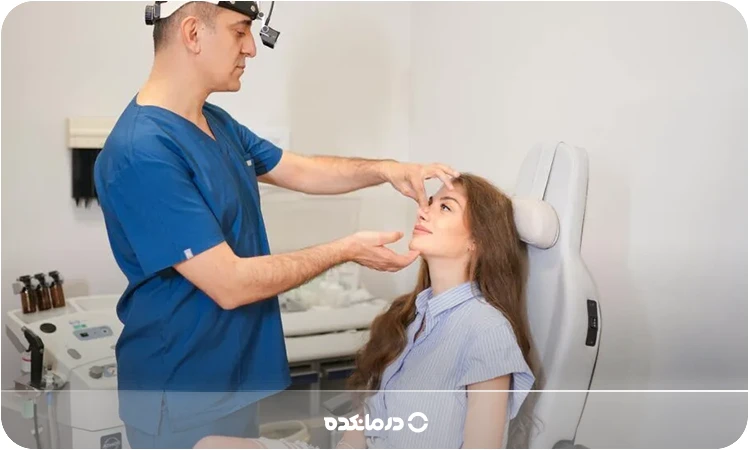 تصویر پزشکی که در حال معاینه فرم بینی بیمار است را می بینید